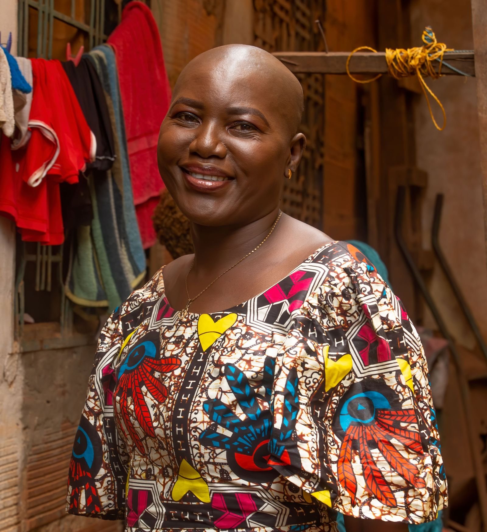 Portrait souriant d'une femme vêtue d'une robe en pagne aux motifs colorés