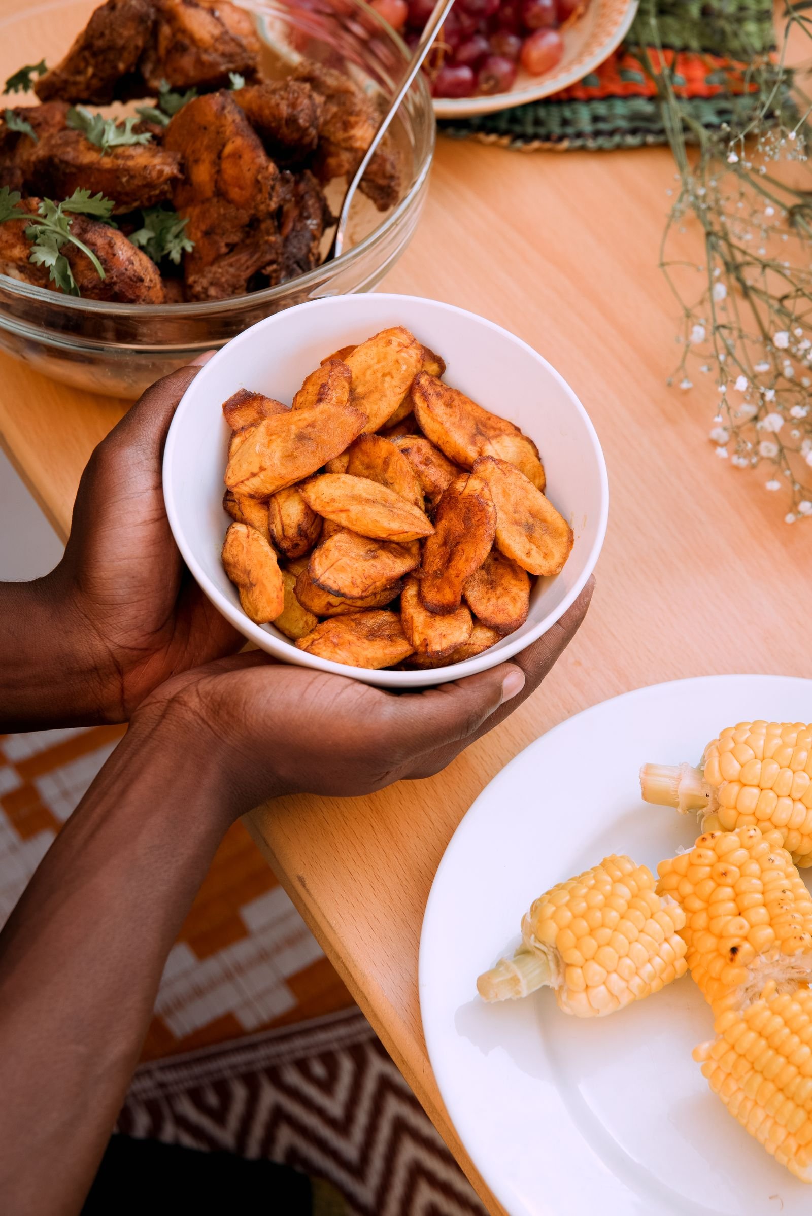 Repas camerounais de plantains frits, poulet et maïs