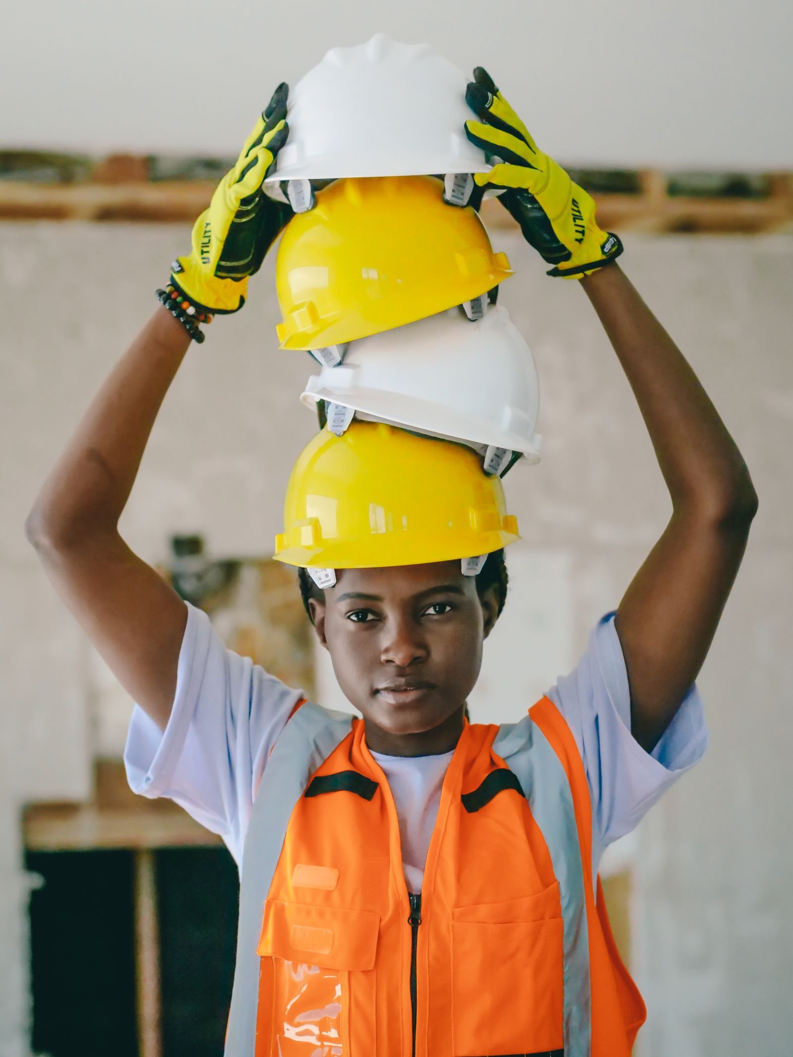 Ingénieure en gilet de sécurité tenant des casques de chantier