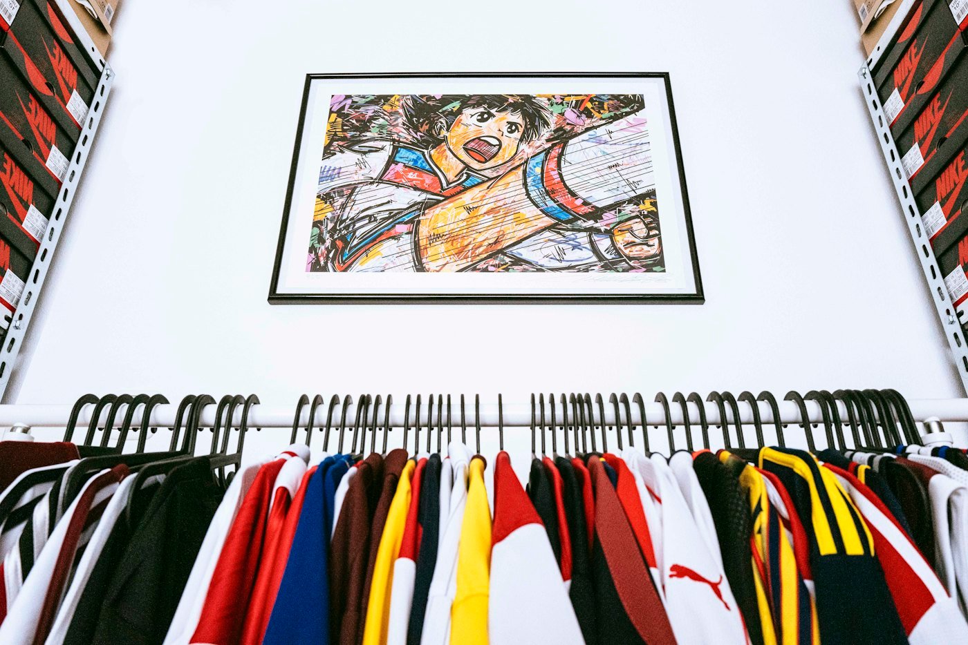 Portant chargé de maillots de football de toutes les couleurs sous un cadre illustré
