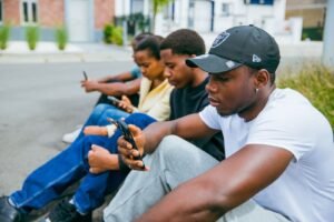 Young people sitting outdoors using their smartphones