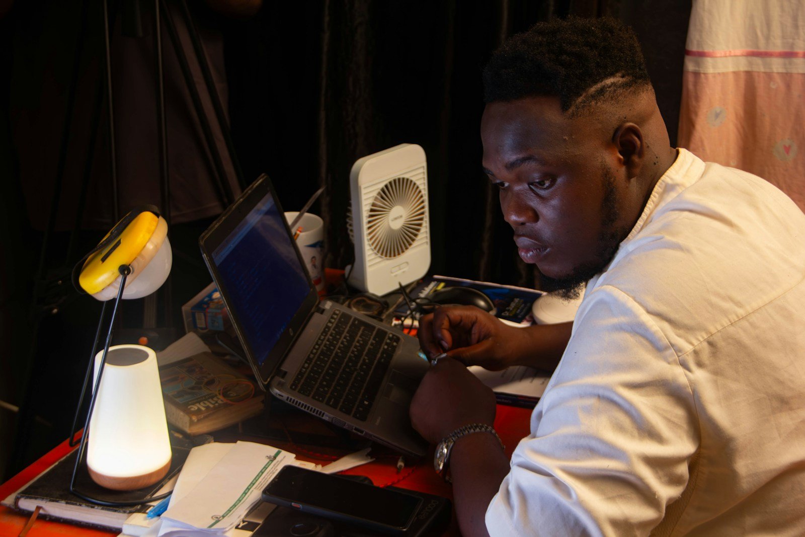 Two people working on laptops at night
